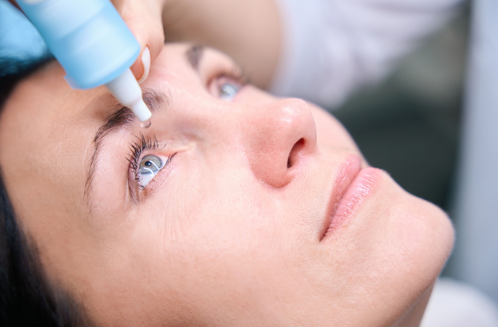 A close-up of a patient getting eye-dilating eye drops at her comprehensive eye exam.